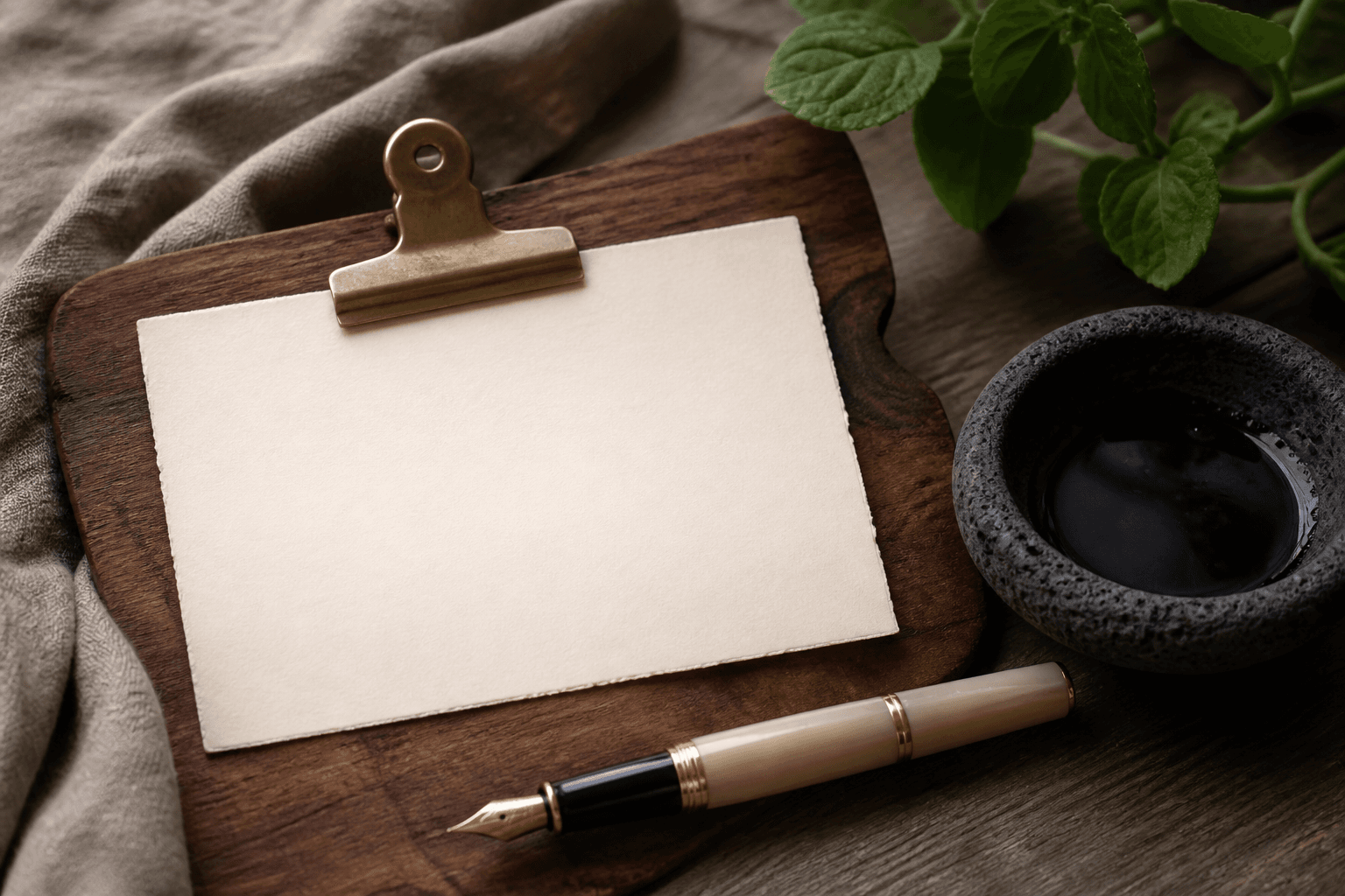 A blank unused ivory card under a brass clip on a koa pass, no stars, no writing, fountain pen.