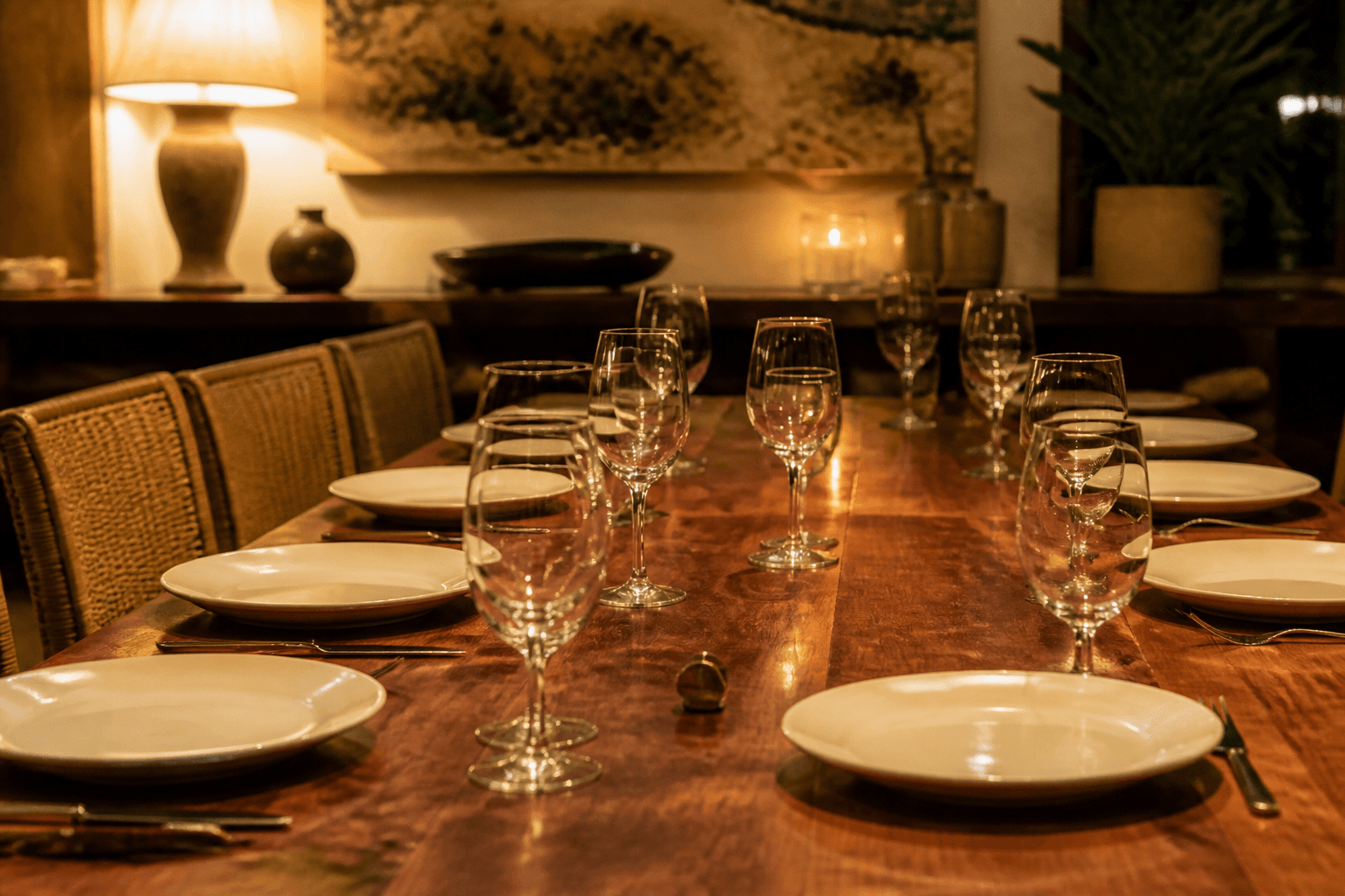 Unused extra empty glasses and unused ivory plates on a koa dining table, brass clip.