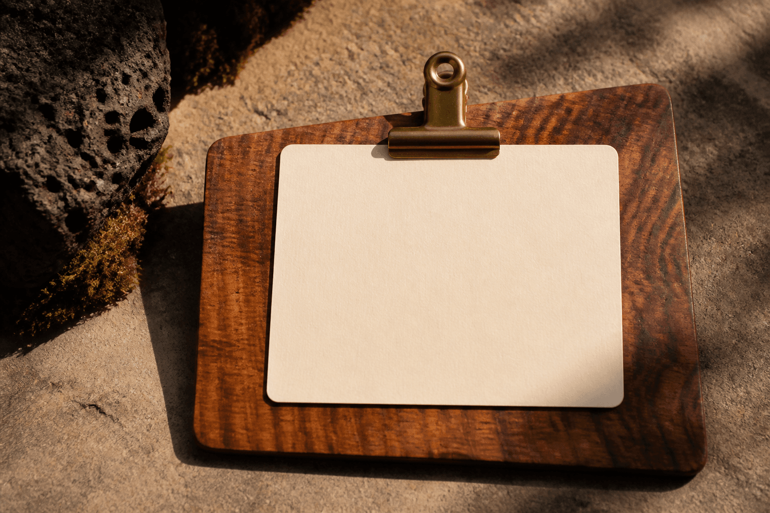 A blank unused ivory card under a brass clip on a koa pass, no stars, no writing.