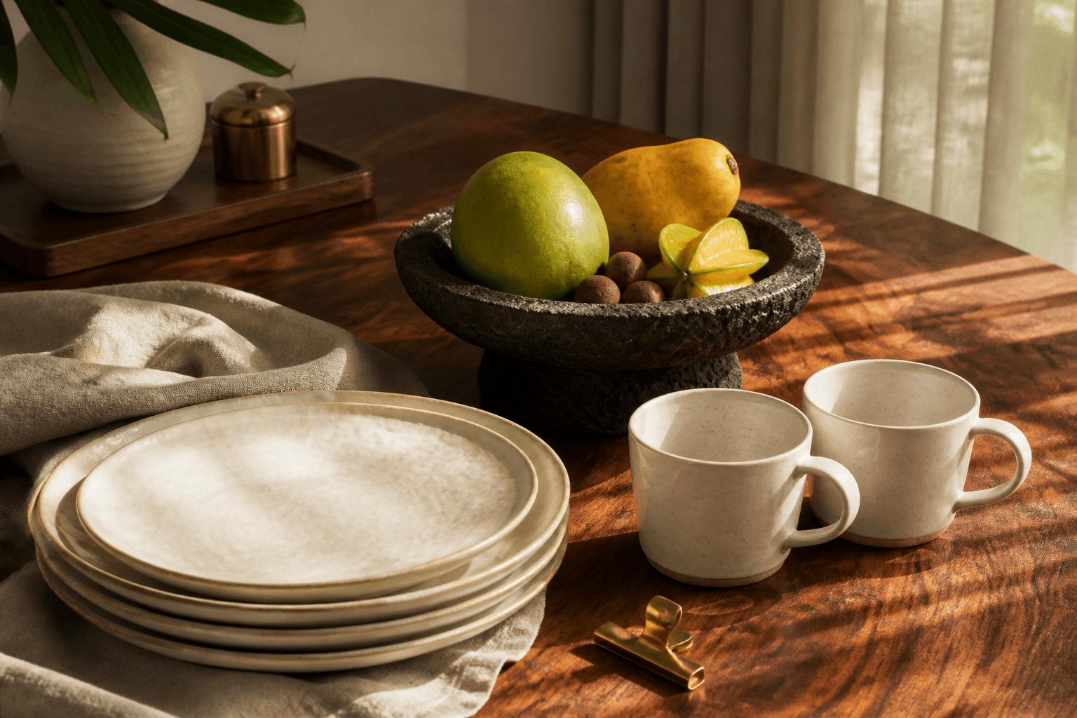 Unused ivory brunch plates, unused fruit in a volcanic-stone bowl, empty coffee cups, morning light.
